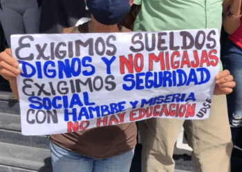 ARCHIVO - Una manifestante venezolana sostiene una pancarta en una protesta por mejores salarios, en Caracas. [Foto: Álvaro Algara, VOA]