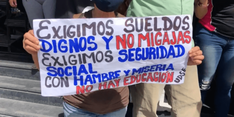 ARCHIVO - Una manifestante venezolana sostiene una pancarta en una protesta por mejores salarios, en Caracas. [Foto: Álvaro Algara, VOA]
