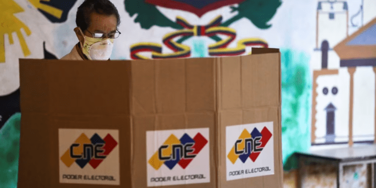 ARCHIVO - Un hombre parado frente a una cabina de votación en un colegio electoral durante las elecciones parlamentarias en Caracas, Venezuela, en diciembre de 2020.