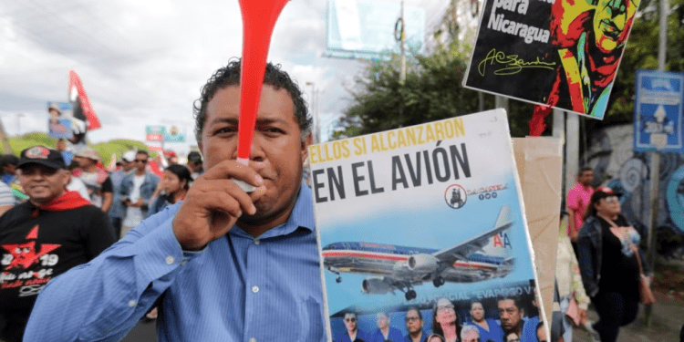 Un manifestante sostiene un cartel con un mensaje que dice en español; “Caben todos en el avión”, refiriéndose a los presos del gobierno del presidente Daniel Ortega que fueron liberados, despojados de su ciudadanía y trasladados a Estados Unidos.
