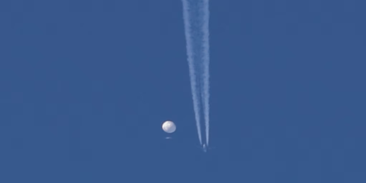 Un gran globo se desplaza sobre el área de Kingston, N.C., con un avión y su estela debajo de él. Estados Unidos dice que es un globo espía chino que se mueve hacia el este sobre EEUU a una altitud de 18.600 metros. (Brian Branch via AP)