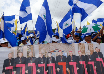 ARCHIVO - Manifestantes antigubernamentales sostienen una pancarta con un grupo de cardenales católicos, y una cita del papa Juan Pablo II en Managua, Nicaragua, el 28 de julio de 2018.