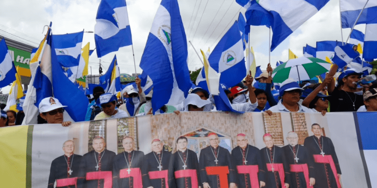 ARCHIVO - Manifestantes antigubernamentales sostienen una pancarta con un grupo de cardenales católicos, y una cita del papa Juan Pablo II en Managua, Nicaragua, el 28 de julio de 2018.