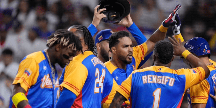 Anthony Santander (centro) es felicitado por sus compañeros de Venezuela tras batear un jonrón ante República Dominicana, en un duelo del Clásico Mundial, realizado el sábado 11 de marzo de 2023, en Miami (AP Foto/Wilfredo Lee)