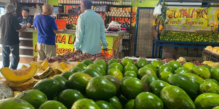 Clientes se aprestan para pagar sus compras de comida en una venta de frutas, vegetales y víveres en Maracaibo, Venezuela, el 13 de julio de 2023. Expertos hablan hoy de una recesión.