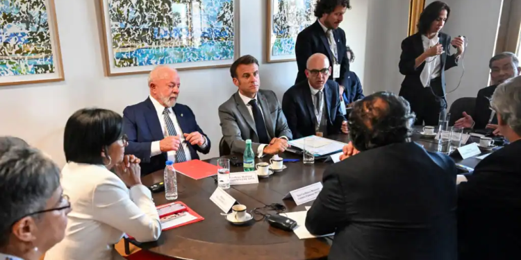 El presidente de Francia, Emmanuel Macron, lidera una reunión sobre el diálogo en Venezuela junto a 3 mandatarios latinoamericanos y delegados del gobierno de Nicolás Maduro y la oposición, en los extremos de la foto, en Bruselas, Bélgica.