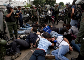 Militares venezolanos rodean a un grupo de estudiantes y manifestantes opositores detenidos el 14 de mayo de 2014 en Caracas. Un fiscal en Argentina imputó este jueves a comandantes y miembros de la Guardia Nacional Bolivariana venezolana por esas represiones.