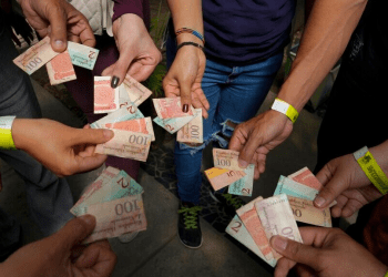 Turistas muestran los billetes viejos de bolívares para usarlos como tiques para intercambiarlos por comida en un tour realizado en Caracas, Venezuela, el 21 de agosto de 2021. La inflación entre enero y junio fue de 100 puntos, según una organización no gubernamental.