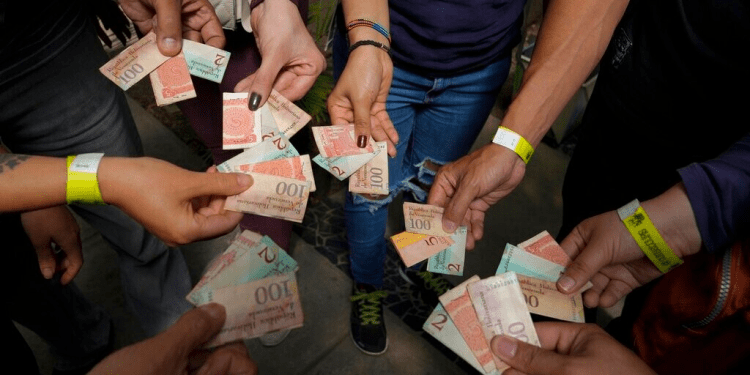 Turistas muestran los billetes viejos de bolívares para usarlos como tiques para intercambiarlos por comida en un tour realizado en Caracas, Venezuela, el 21 de agosto de 2021. La inflación entre enero y junio fue de 100 puntos, según una organización no gubernamental.