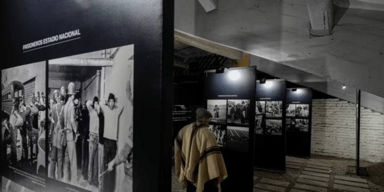 El exdetenido Héctor Hipólito Álvarez mira las fotos antes del inicio de una presentación en honor al cantautor chileno Víctor Jara en el Estadio Nacional que alguna vez fue utilizado como prisión y lugar de tortura, en Santiago, Chile, el sábado 19 de agosto de 2023.
