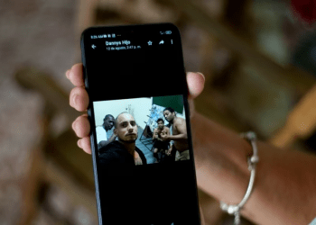 Marilin Vinent sostiene una fotografía de su hijo Dannys Castillo con otros cubanos en Rusia, enviada en un mensaje de su hijo durante una entrevista en su casa en La Habana, Cuba, el viernes 8 de septiembre de 2023.