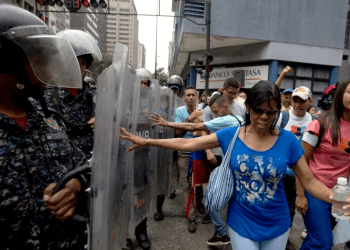 Manifestantes empujan los escudos de la policía venezolana mientras protestan contra el gobierno de Nicolás Maduro en Caracas, el 18 de Julio de 2018. La ONG Foro Penal reporta más de 15.000 presos por razones políticas en Venezuela desde 2014.