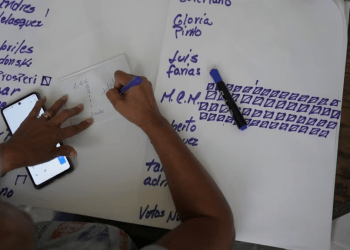 Un miembro de mesa de la primaria opositora lleva relación de los votos obtenidos por los distintos candidatos en un centro de participación de Catia, en Caracas, este domingo pasado.