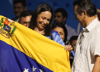María Corina Machado, inminente ganadora de la primaria presidencial opositora, sostiene una bandera de Venezuela en su comando de campaña, amaneciendo este lunes 23 de octubre de 2023.