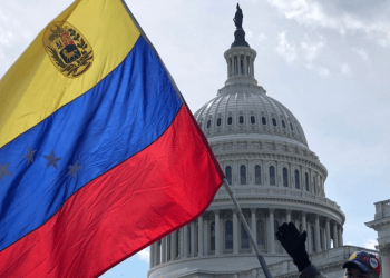Venezolano sostiene su bandera frente al Capitolio de EE.UU., en Washington.