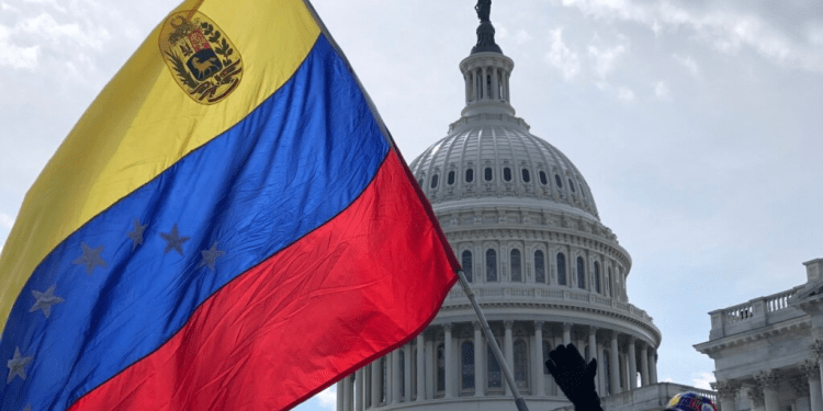 Venezolano sostiene su bandera frente al Capitolio de EE.UU., en Washington.