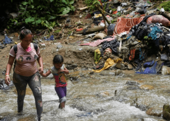 Una migrante camina junto a una niña en Acandi, Colombia, mientras continúan su camino a Estados Unidos, el 9 de Julio de 2023. Este año, siguen creciendo las cifras récord de migración a través del Tapón del Darién, que conecta a Colombia y Panamá.