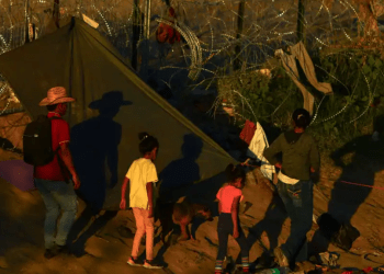Migrantes que buscan asilo en Estados Unidos caminan cerca de una cerca con púas, en Ciudad Juarez, México. Estados Unidos y Venezuela acordaron un plan de repatriación con vuelos directos de quienes no tengan base legal para quedarse en el país norteamericano.