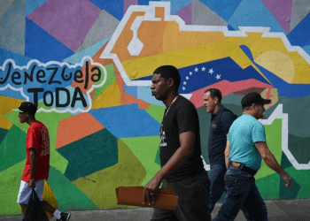 Personas caminan frente a un mural en la comunidad del 23 de Enero, en Caracas, a favor del referendo consultivo sobre el Esequibo. La votación se realizará este domingo en toda Venezuela.