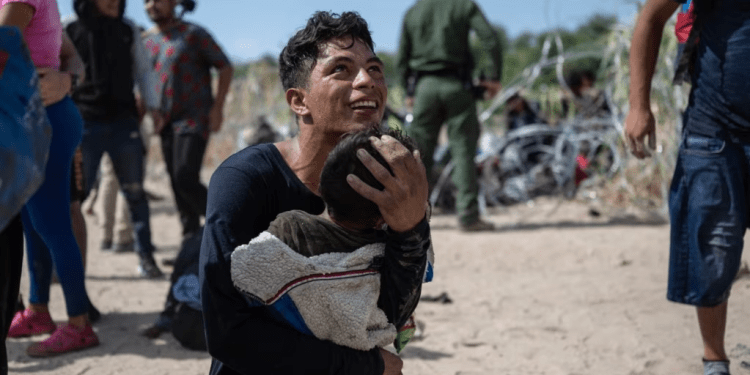 Una familia migrante venezolana reacciona luego de cruzar una barricada hacia suelo estadounidense en Eagle Pass, Texas, el 25 de septiembre de 2023. Miles de migrantes venezolanos han sido deportados desde Estados Unidos.