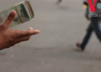 Personas dedicadas al cambio de dinero de manera informal en Venezuela venden pacas de bolívares, la devaluada moneda local, para operaciones de menudeo, completar un pago o para el pasaje del bus. Más del 90 % de los precios en el país están marcados en la moneda estadounidense, según expertos.