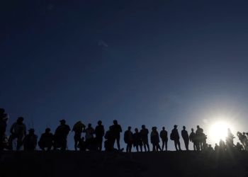 ARCHIVO - Migrantes se encuentran en el lado mexicano de la frontera entre Estados Unidos y México, a orillas del Río Grande, en Ciudad Juárez, México, el 29 de marzo de 2023.
