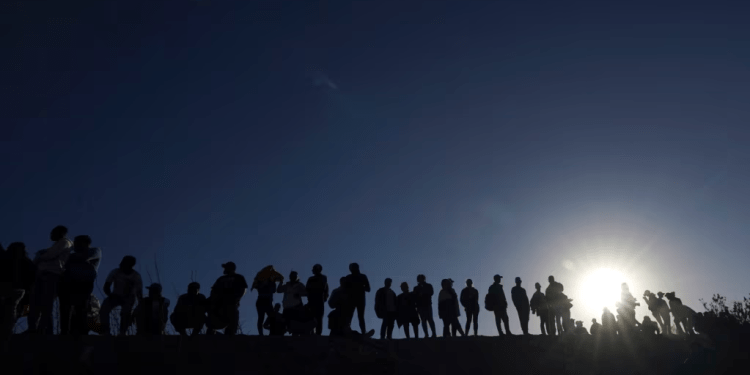 ARCHIVO - Migrantes se encuentran en el lado mexicano de la frontera entre Estados Unidos y México, a orillas del Río Grande, en Ciudad Juárez, México, el 29 de marzo de 2023.