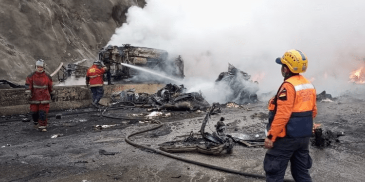 Bomberos y miembros de Protección Civil sofocan el fuego luego de un accidente que dejó al menos 14 muertos en la autopista Gran Mariscal de Ayacucho, en Miranda, este miércoles 13 de diciembre de 2023.