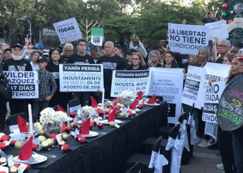 Una mesa vestida de negro, decoración navideña y sillas vacías intenta sensibilizar sobre la situación que viven los presos políticos y sus familiares, especialmente en días festivos.