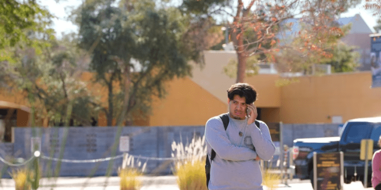 Un estudiante de la Universidad de Nevada campus Las Vegas habla por teléfono luego de que se reportó un tiroteo en el lugar, el 6 de diciembre de 2023, en Las Vegas, EEUU.