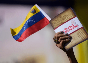 Una mujer sostiene una bandera venezolana y un libro sobre el Esequibo en Caracas, el pasado 29 de noviembre de 2023.