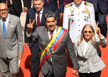 El presidente venezolano Nicolás Maduro y su esposa, Cilia Flores, saludan a su entrada al Palacio Federal Legislativo, en Caracas, este lunes, para presentar su memoria y cuenta anual. Les acompaña el presidente del parlamento, Jorge Rodríguez, a la izquierda en la fotografía.