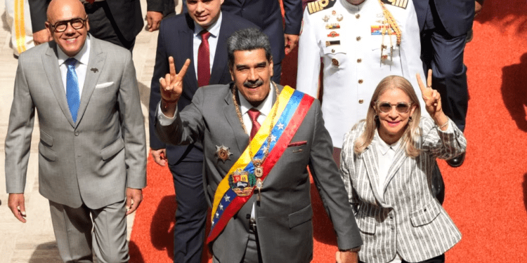 El presidente venezolano Nicolás Maduro y su esposa, Cilia Flores, saludan a su entrada al Palacio Federal Legislativo, en Caracas, este lunes, para presentar su memoria y cuenta anual. Les acompaña el presidente del parlamento, Jorge Rodríguez, a la izquierda en la fotografía.