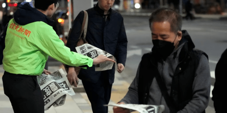 Personas en Tokio leen la edición extraordinaria de un diario reportando los sismos del 1 de enero en Japón.