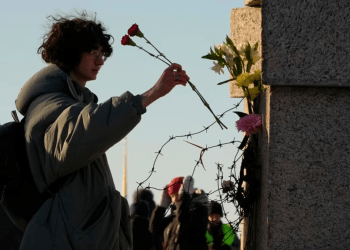 Una mujer deposita flores mientras la gente rinde homenaje a Alexei Navalny en el Memorial a las Víctimas de la Represión Política en San Petersburgo, Rusia, el 18 de febrero de 2024.