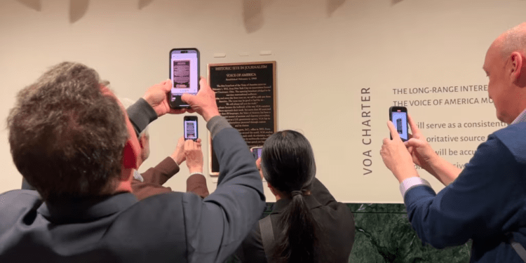 Los invitados fotografían la placa en honor a la VOA como un sitio histórico en el periodismo, el 2 de febrero de 2024 en Washington. (Cristina Caicedo Smit/VOA)