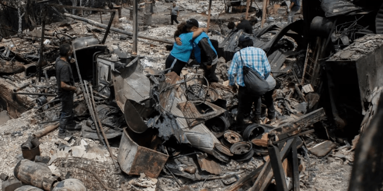 Residentes se abrazan entre los restos de casas calcinadas luego de que incendios forestales alcanzaron su vecindario, el domingo 4 de febrero de 2024, en Viña del Mar, Chile.