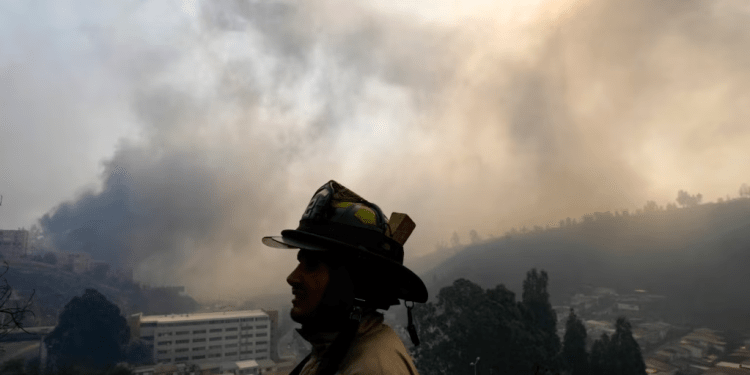 La silueta de un bombero se recorta contra un cielo lleno de humo mientras un incendio forestal se propaga hacia Viña del Mar, Chile, el sábado 3 de febrero de 2024.