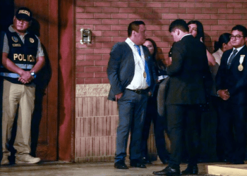 Policías y fiscales esperan a las afueras de la residencia de la presidenta peruana Dina Boluarte durante un allanamiento por una investigación sobre presunta corrupción, en Lima, este sábado 30 de marzo de 2024.