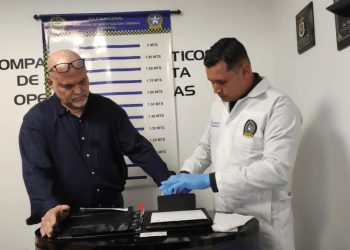 Un policía toma huellas dactilares al ex comandante de las Autodefensas Unidas de Colombia (AUC), Salvatore Mancuso, luego de llegar a Colombia extraditado de Estados Unidos al Comando Aéreo de Transporte Militar (CATAM) en Bogotá, Colombia, el 27 de febrero de 2024.