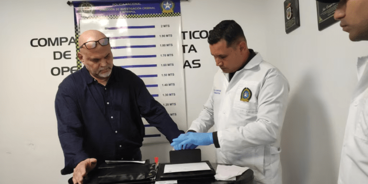 Un policía toma huellas dactilares al ex comandante de las Autodefensas Unidas de Colombia (AUC), Salvatore Mancuso, luego de llegar a Colombia extraditado de Estados Unidos al Comando Aéreo de Transporte Militar (CATAM) en Bogotá, Colombia, el 27 de febrero de 2024.