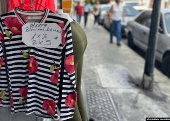 Una venta de ropa de algodón exhibe ofertas de sus prendas por hasta 2 piezas por 5 dólares en Caracas, Venezuela.