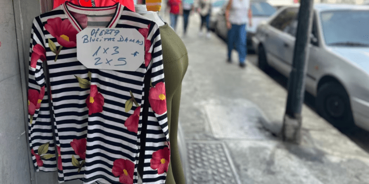 Una venta de ropa de algodón exhibe ofertas de sus prendas por hasta 2 piezas por 5 dólares en Caracas, Venezuela.
