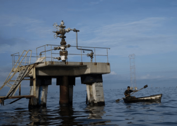 Un pescador navega frente a una perforadora petrolera fuera de operaciones en el lago Maracaibo en Venezuela, a principios del 12 de octubre de 2022.