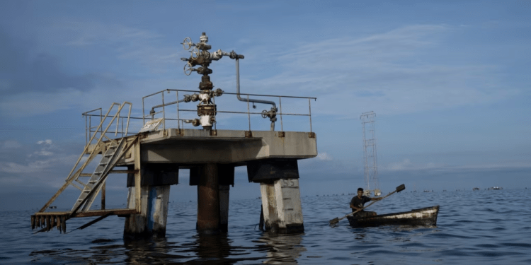 Un pescador navega frente a una perforadora petrolera fuera de operaciones en el lago Maracaibo en Venezuela, a principios del 12 de octubre de 2022.