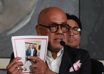 Jorge Rodríguez, presidente del Parlamento de mayoría oficialista de Venezuela muestra una fotografía en la que se le ve junto a Brian Nichols y el facilitador de Qatar durante un proceso directo de negociaciones.