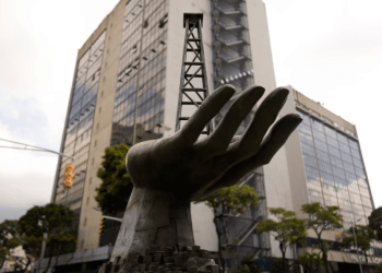 La escultura de una mano sosteniendo un pozo petrolero se exhibe al frente de una sede de la estatal PDVSA, en Caracas, el 21 de marzo de 2023.