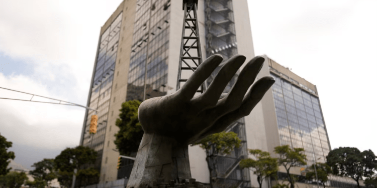 La escultura de una mano sosteniendo un pozo petrolero se exhibe al frente de una sede de la estatal PDVSA, en Caracas, el 21 de marzo de 2023.