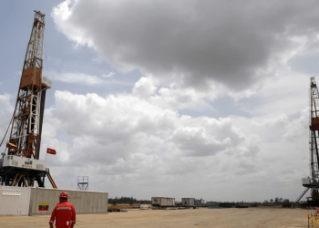 Un trabajador de un yacimiento petrolífero camina junto a plataformas de perforación en un pozo operado por la petrolera estatal venezolana, PDVSA., 16 de abril, 2015. REUTERS/Carlos Garcia Rawlins/File Photo