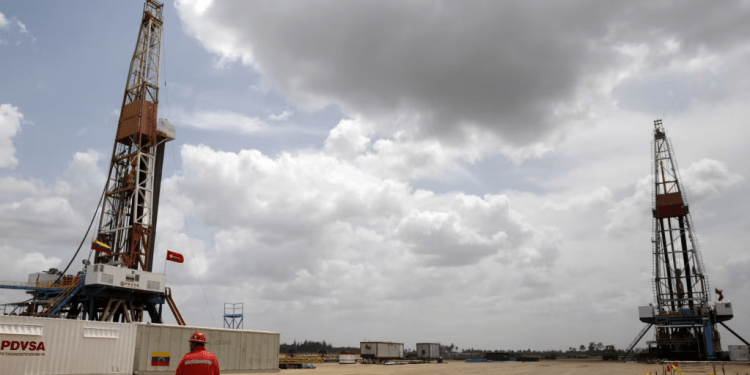 Un trabajador de un yacimiento petrolífero camina junto a plataformas de perforación en un pozo operado por la petrolera estatal venezolana, PDVSA., 16 de abril, 2015. REUTERS/Carlos Garcia Rawlins/File Photo
